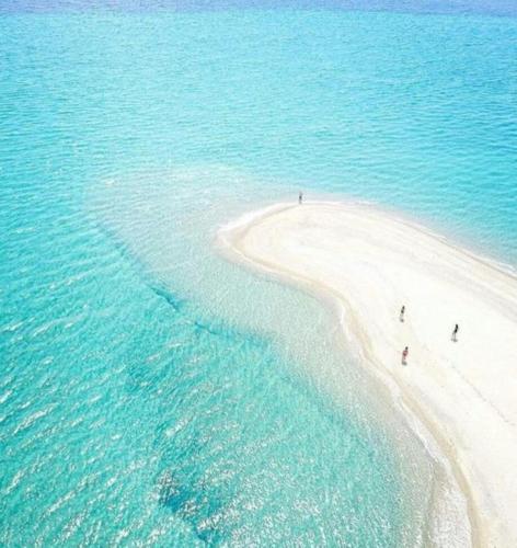 people walking on a white beach in the ocean at Elizabeth Hotel in Kallithea Halkidikis