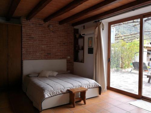 1 dormitorio con 1 cama y puerta que da a un patio en Villa Maria, en Dorgali