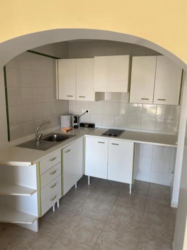 a kitchen with white cabinets and a sink at Apartment Alcudia Beach in Port d'Alcudia