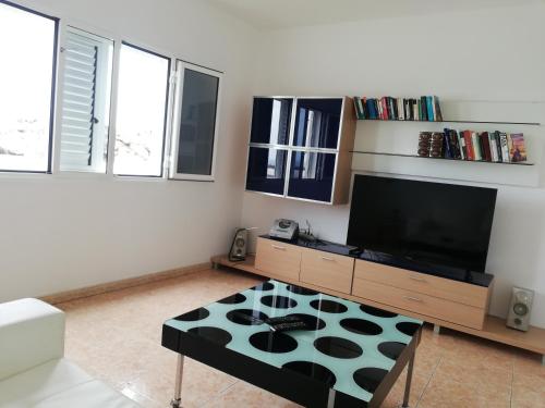 a living room with a tv and a table at Villa Tranquila in Orzola