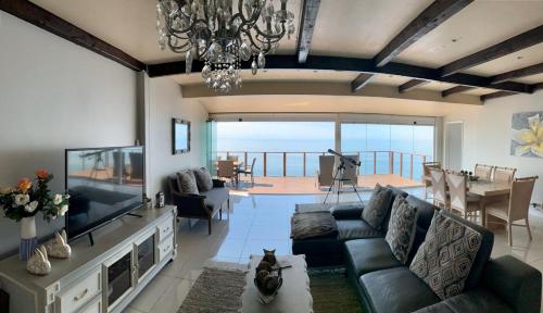a living room with a couch and a flat screen tv at Lalapanzi in Fish hoek