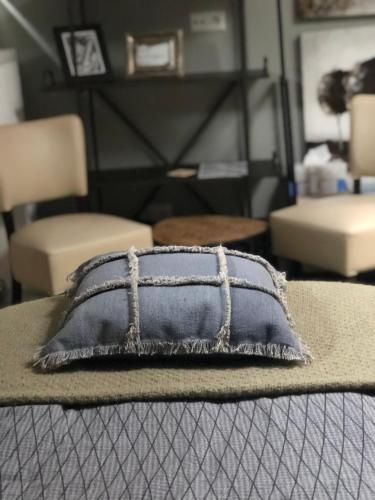 a pillow sitting on top of a bed with chairs at Het Huis van de Wadden in Den Oever