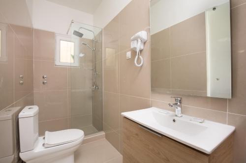 W łazience znajduje się toaleta, umywalka i prysznic. w obiekcie Paralia studios w mieście Kavos