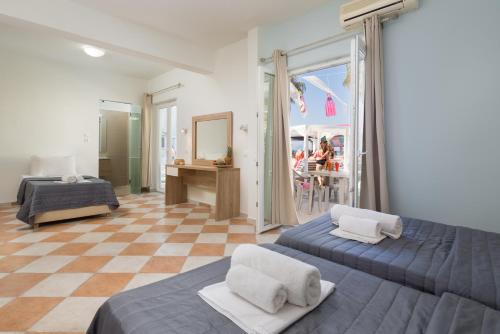 sypialnia z 2 łóżkami i podłogą wyłożoną szachownicą w obiekcie Paralia studios w mieście Kavos