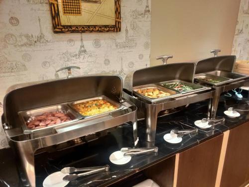 a buffet line with three trays of food on it at Discovery Motel - Nangang臺北市旅館349-2號 in Taipei