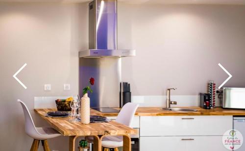 - une cuisine avec une table, des chaises et une cuisinière dans l'établissement Le loft en bulles, à Saint-Maurin