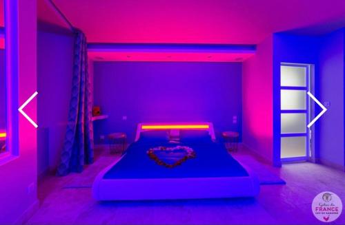 - une chambre dotée d'un lit avec une lumière violette dans l'établissement Le loft en bulles, à Saint-Maurin