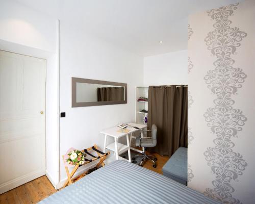 1 dormitorio con cama, escritorio y mesa en Crypto Prestige - Gare et Centre - Studio et T3 en Angers