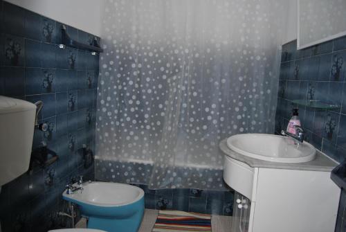 e bagno con lavandino, servizi igienici e doccia. di Apartamentos Mota a Nazaré