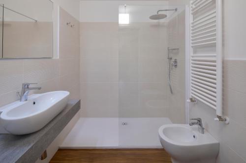 a white bathroom with a sink and a shower at Hotel Paradiso Conca d'Oro in Nago-Torbole