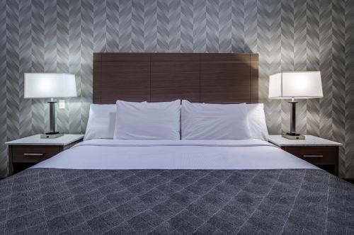 a bedroom with a large bed with two lamps at Monte Carlo Inn Markham in Markham