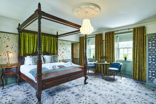 a bedroom with a canopy bed and a table and chairs at Monkstadt 1745 Luxury Lodge in Portree