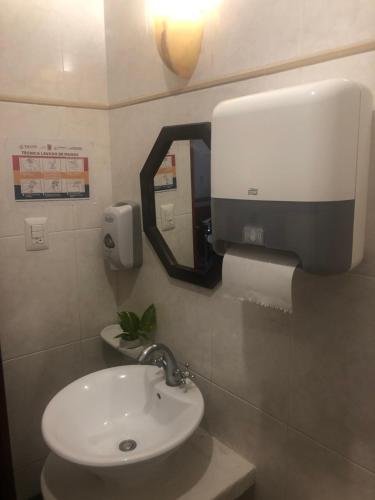 a bathroom with a sink and a mirror on the wall at Castelmar Hotel in Campeche