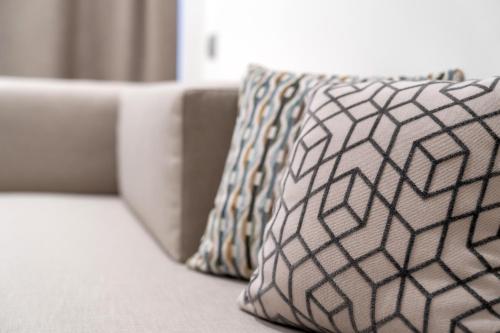 a white couch with two pillows on it at Hotel Garden Sea Wellness & Spa 4 stelle superior in Caorle