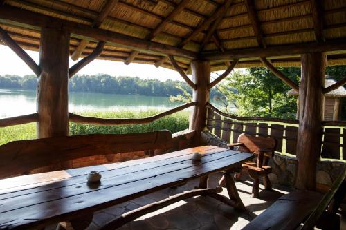a wooden bench in a cabin with a view of a lake at Dom nad jeziorem Ublik z sauną i jacuzzi in Ublik