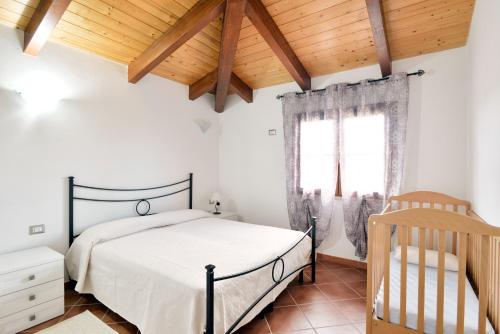 a bedroom with a bed and a wooden ceiling at Sa Mandracchina in Olmedo