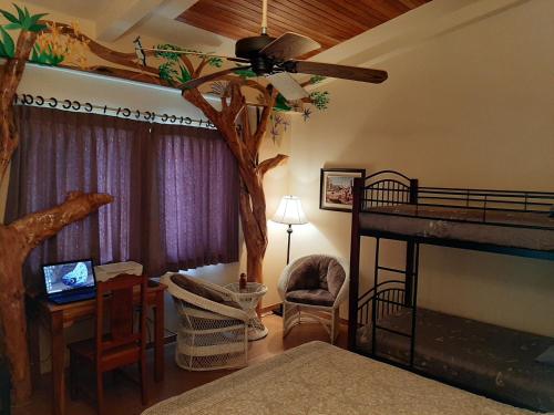 a bedroom with a tree in the corner of a room at Marita's Bed and Breakfast in Nuevo Arenal