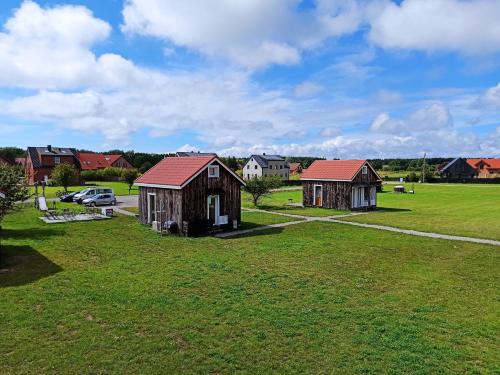 eine Luftansicht von zwei kleinen Gebäuden auf einem Feld in der Unterkunft Camping Klevas in Karklė