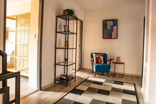 a living room with a blue chair and a mirror at K-house in Liptovský Mikuláš