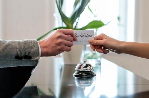 a person handing another person a piece of paper at Hotel Madelaine in Lwówek Śląski