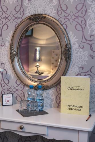 a mirror on top of a table with water bottles at Hotel Madelaine in Lwówek Śląski