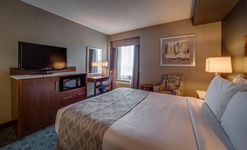 a hotel room with a bed and a flat screen tv at Monte Carlo Inn Markham in Markham