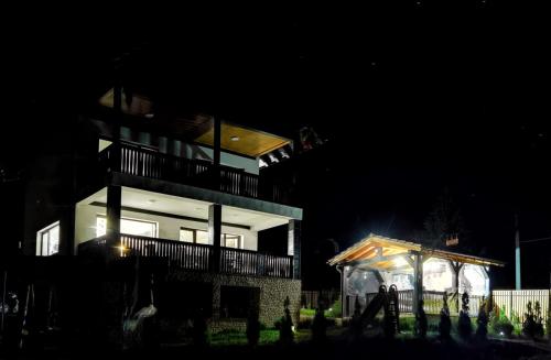 a large house at night with a gazebo at Aqualina Colibita - pe malul lacului in Colibiţa