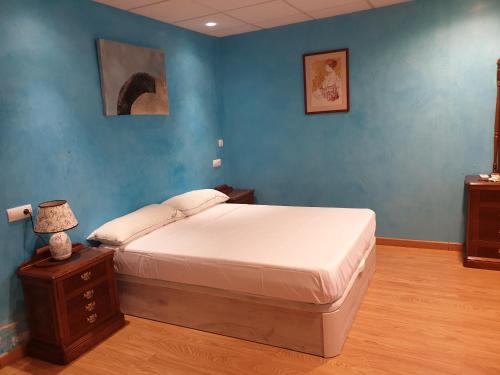 sypialnia z łóżkiem i niebieską ścianą w obiekcie Hostal Alfil w mieście Cazalegas