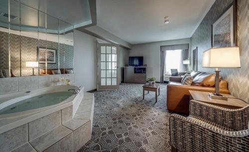 a large bathroom with a tub and a couch at Monte Carlo Inn Markham in Markham