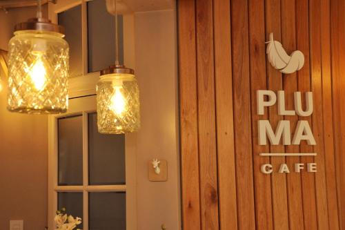 two lights hanging from a wall with a sign at Posada de las Aguilas Hotel Boutique in Ezeiza