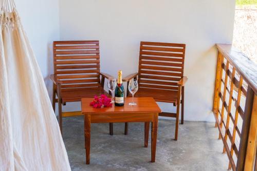 two chairs and a table with a bottle of champagne and flowers at Villa Zen Hotel in Camocim