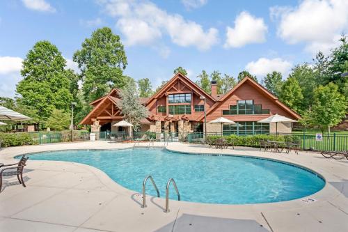 una piscina frente a una casa de madera en Hilton Vacation Club Bent Creek Golf Village Gatlinburg, en Gatlinburg