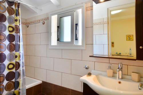 a bathroom with a sink and a mirror and a tub at Alex Apartment Suites in Virós