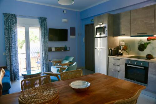a kitchen with a wooden table and a kitchen with blue walls at Casa Anthos in Chania Town