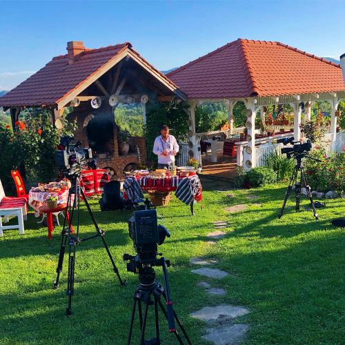 a man standing in front of a house with several cameras at Conacul Paloși in Horezu