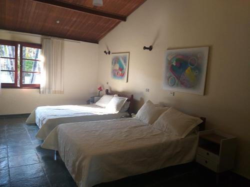 a bedroom with two beds and a window at Boituva Rancho dos Arcos in Boituva