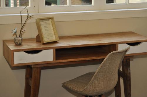 a wooden desk with a chair and a book at Posada de las Aguilas Hotel Boutique in Ezeiza
