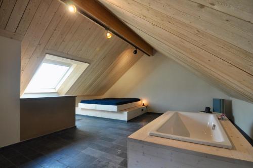 ein Bad im Dachgeschoss mit einer Badewanne und einem Fenster in der Unterkunft Ferienhaus Baustert in Baustert
