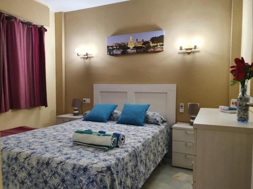 1 dormitorio con 1 cama grande con almohadas azules en Erisa I, en Torremolinos