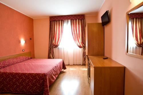 Hotel Colombo في Breda di Piave: غرفه فندقيه بسرير ونافذه