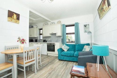 a living room with a blue couch and a table at Cargagh Cottage in Annacloy