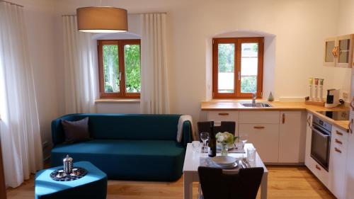 een woonkamer met een blauwe bank en een tafel bij HOF ELF in Ursensollen