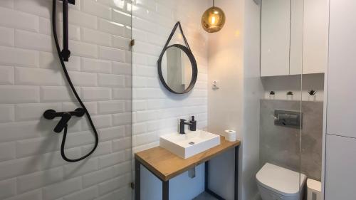 y baño con lavabo y espejo. en Apartament Rodzinny - Lake Apartments, osiedle Calamo Park - Olsztyn, en Olsztyn