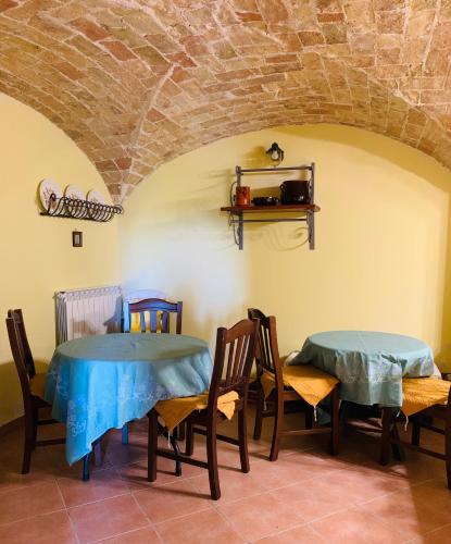 two tables and chairs in a room with a stone wall at Villa Sarno in Montesilvano