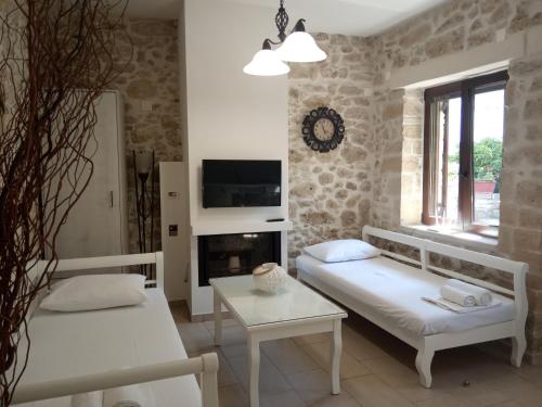 ein Wohnzimmer mit 2 Betten und einem Kamin in der Unterkunft Archontiko Anastasia in Choudetsi