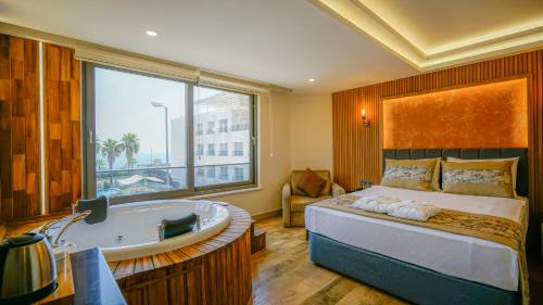 a bedroom with a large bed and a bath tub at Green Beyza Suites in Antalya