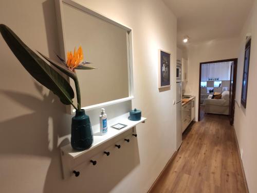 a vase with a flower on a shelf in a hallway at La Casita del Reloj in Santa Cruz de la Palma