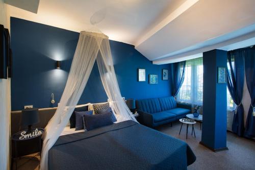 a blue bedroom with a bed and a couch at Sunrise Hotel in Primorsko