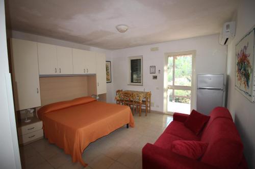 um quarto com uma cama e um sofá vermelho em La Dimora dei Pescatori em Vieste