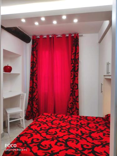 - une chambre avec des rideaux rouges et un lit rouge dans l'établissement Logement de Catherine, à Nice